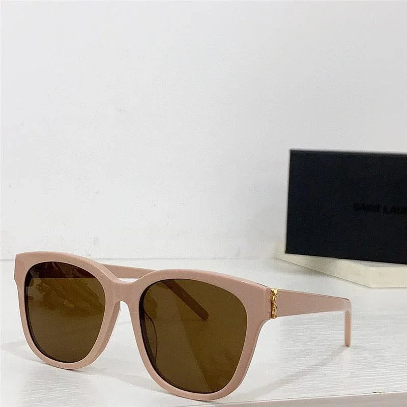 Beige oversized sunglasses with brown polarized lenses on a white tabletop