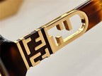 Close-up of luxury sunglasses arm with gold geometric detail and tortoiseshell pattern