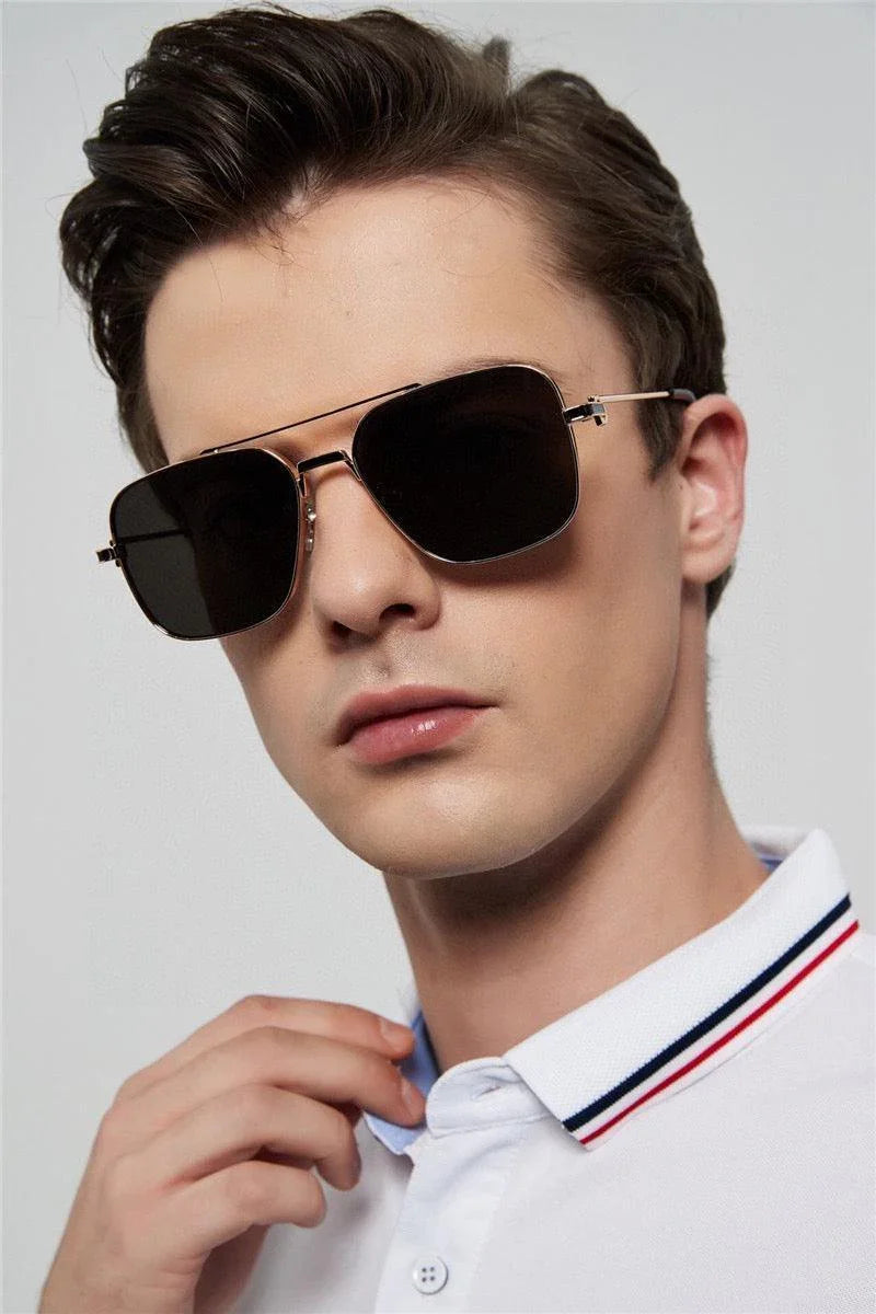 Man wearing black aviator sunglasses with gold frame and white polo shirt