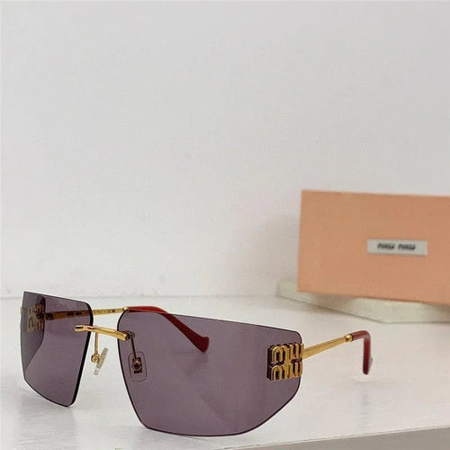 Rimless oversized sunglasses with purple lenses, gold arms, and red ear tips on white surface