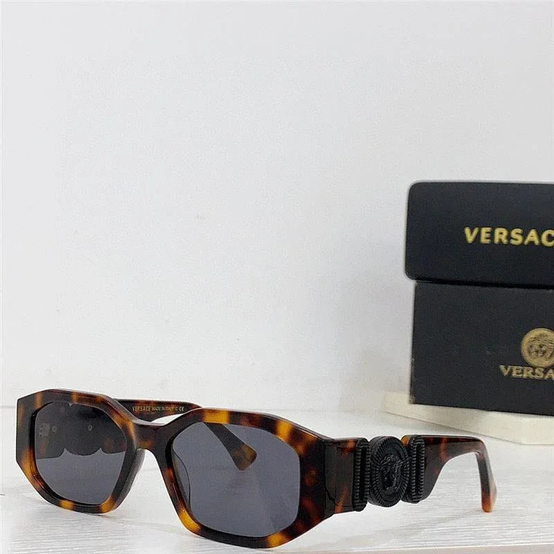 Tortoise shell square sunglasses with dark lenses and decorative side detail, next to branded case