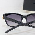 Black cat-eye sunglasses with gradient lenses and gold accent on temple, stylish eyewear