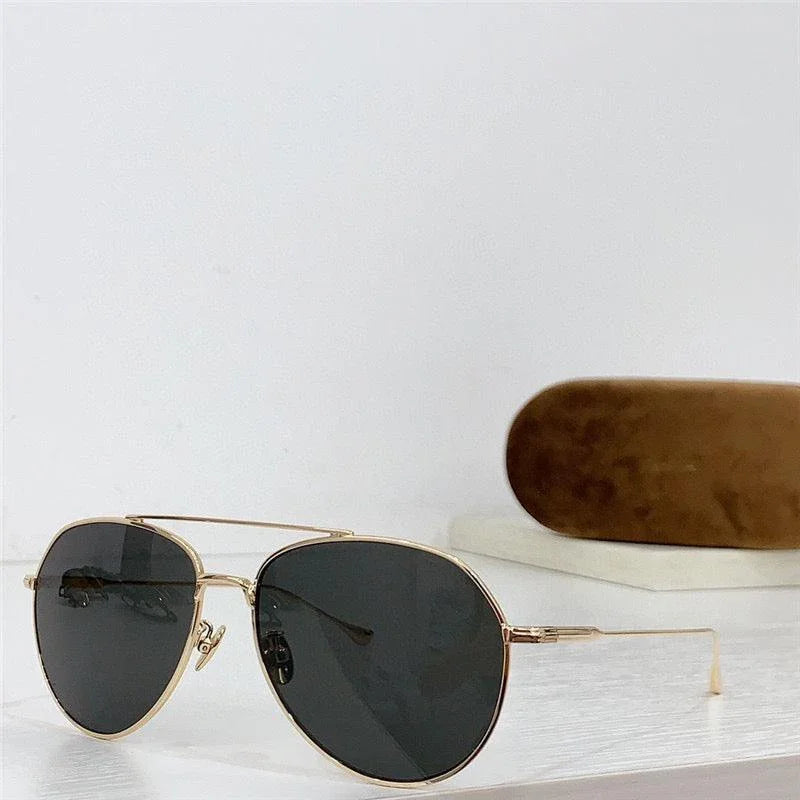 Aviator sunglasses with gold frame and black polarized lenses on white surface with case