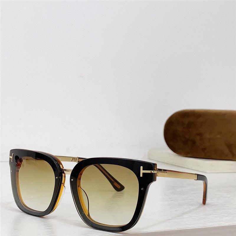 Square oversized sunglasses with gradient lenses and black and gold frames, displayed on a table.