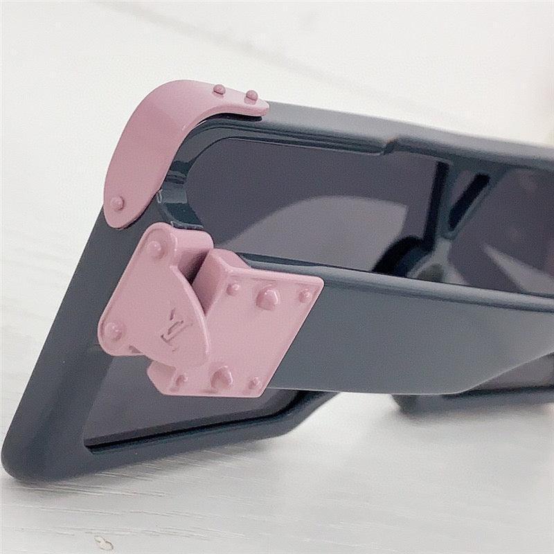 Close-up of stylish sunglasses with dark frames and pink rivet hinge detail