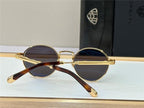 Round sunglasses with gold metal frame and dark lenses on display, tortoise temple tips