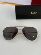 Gold aviator sunglasses with dark lenses and a black case on a white surface
