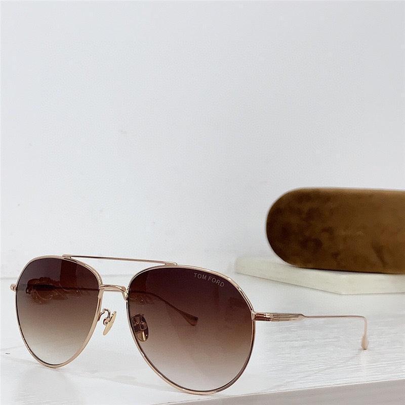 Aviator sunglasses with gold frame and brown gradient lenses, case in background on white surface