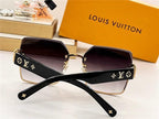 Designer black square sunglasses with gold accents and gradient lenses on display table