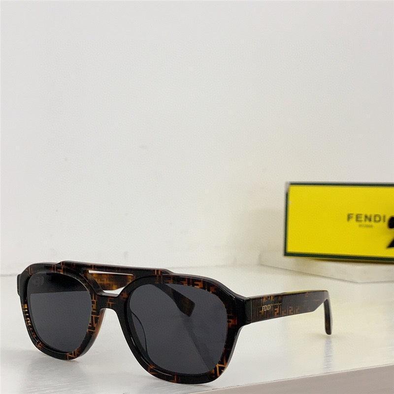 Tortoiseshell sunglasses with black lenses on white surface, yellow Fendi box in background