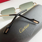 Luxury rimless sunglasses with gold frame and green gradient lenses on a black Cartier case