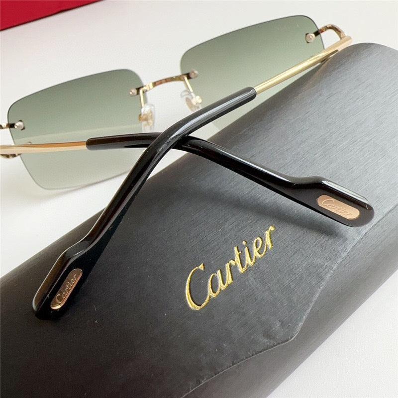 Luxury rimless sunglasses with gold frame and green gradient lenses on a black Cartier case