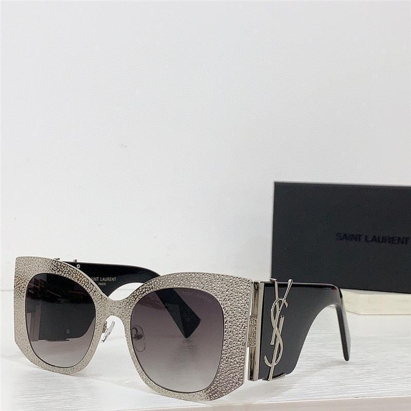 Oversized cat-eye sunglasses with rhinestone-studded frames and gradient lenses on white surface