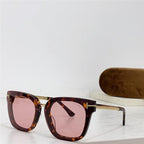 Square tortoiseshell sunglasses with pink lenses and gold arms on white table