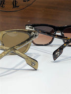 Close-up of two stylish sunglasses with gold and tortoise shell frames, logo on temples