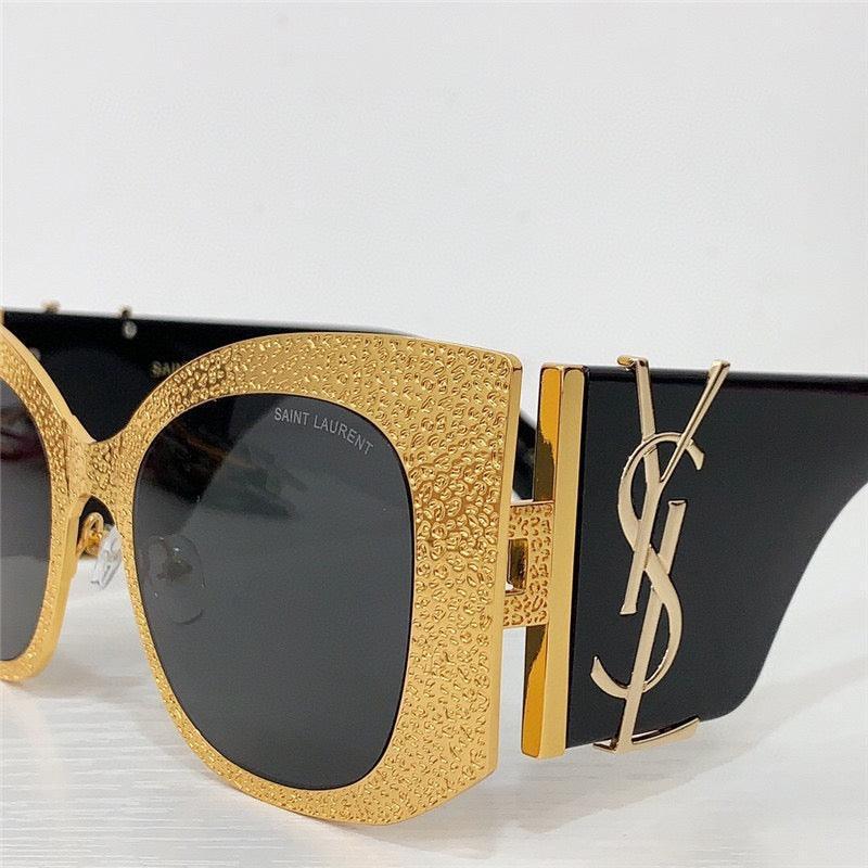 Gold textured oversized sunglasses with black lenses and decorative logo on temples