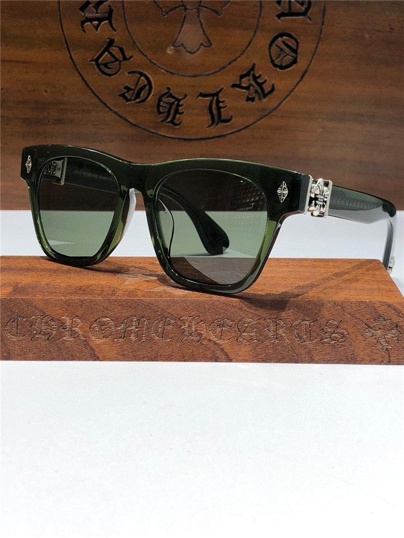 Black rectangular sunglasses with silver accent, dark lenses, displayed on a wooden box.