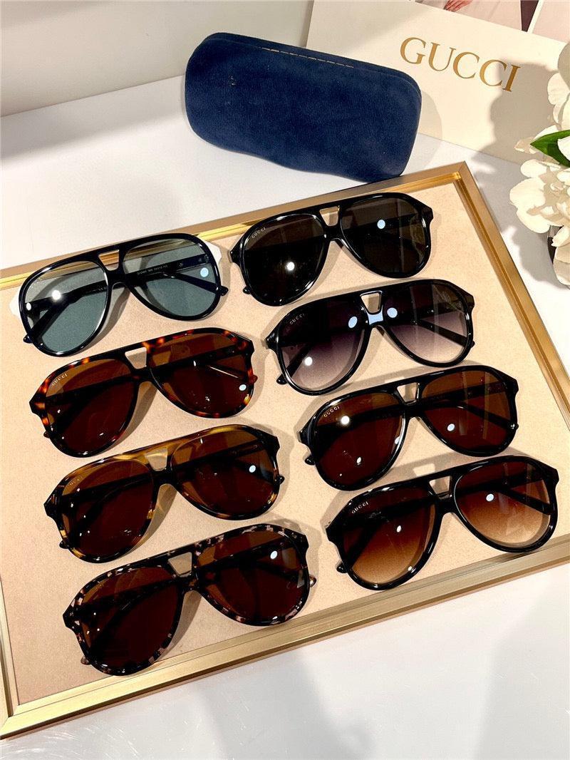 Assorted designer sunglasses with dark lenses in various frame styles on display tray