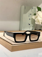 Black rectangular sunglasses with brown lenses on a display tray, sunglasses accessory decor
