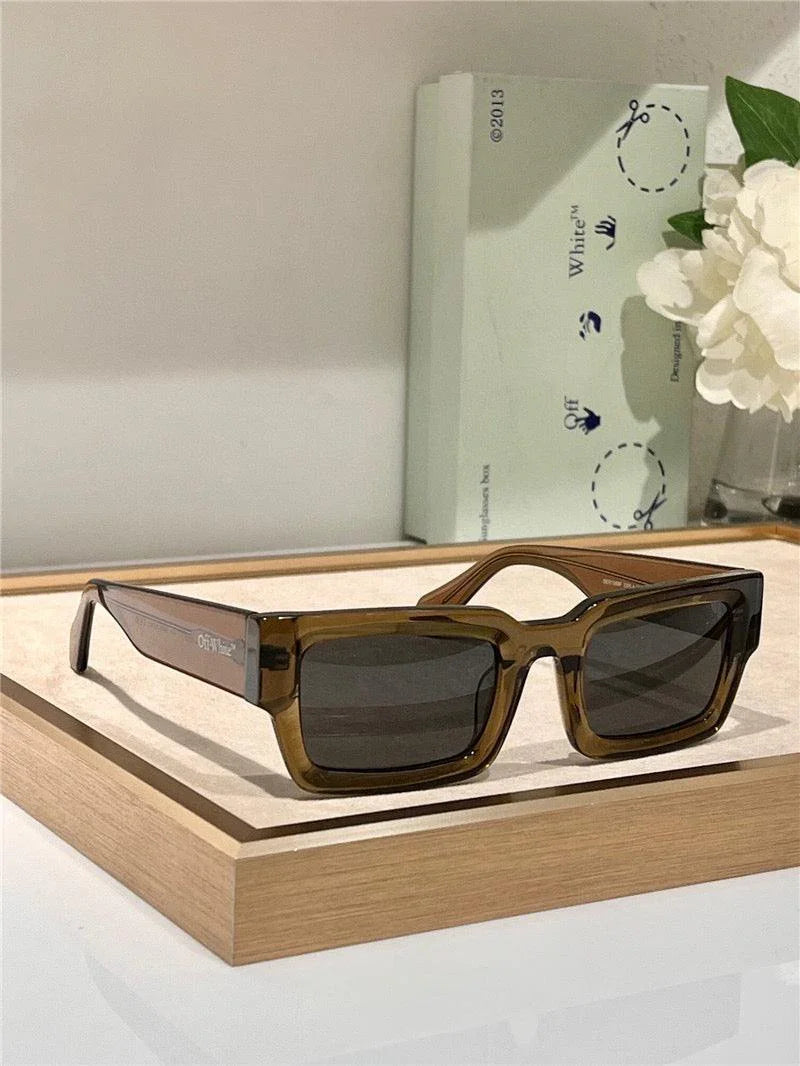 Rectangular brown sunglasses with dark lenses on display tray, modern eyewear fashion