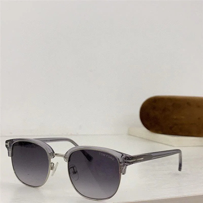 Gray Tom Ford sunglasses with gradient lenses and a case on a white surface