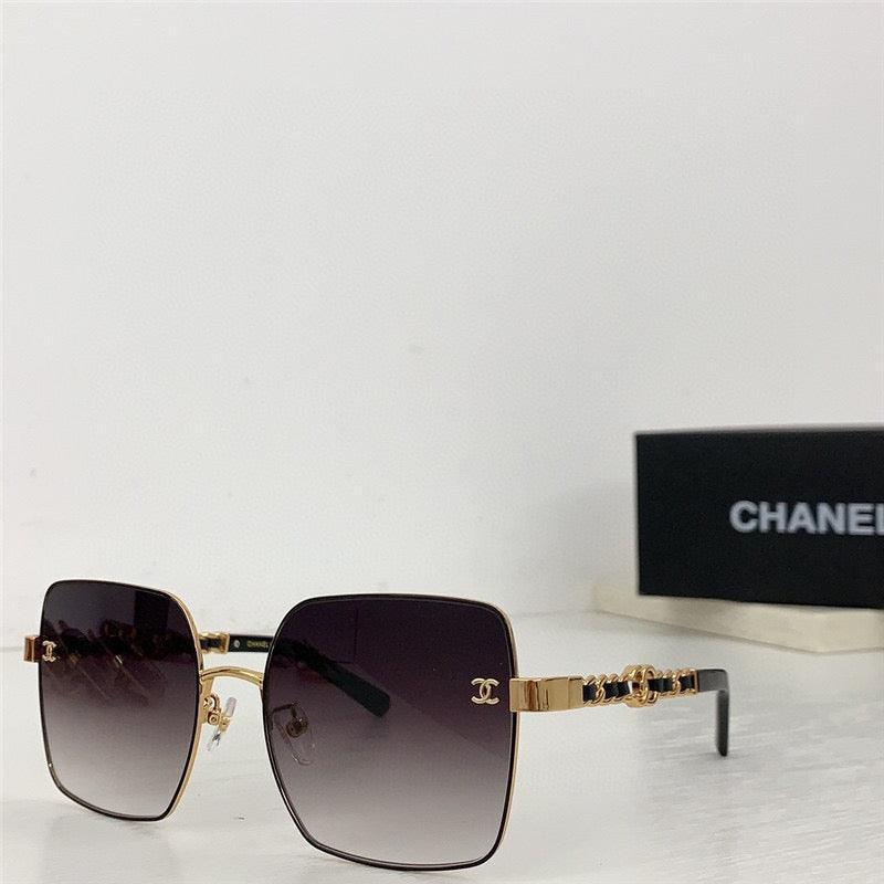 Square oversized sunglasses with gold metal frame, black gradient lenses, and chain detail