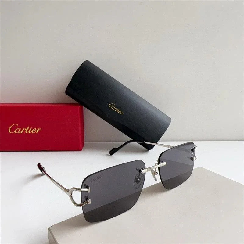 Rimless sunglasses with dark lenses and metal temples, shown with branded case and box.
