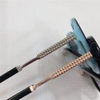 Close-up of luxury sunglasses with gold and silver studded arms and blue gradient frames
