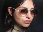 Woman wearing round gradient sunglasses with metal frames, fashion eyewear closeup