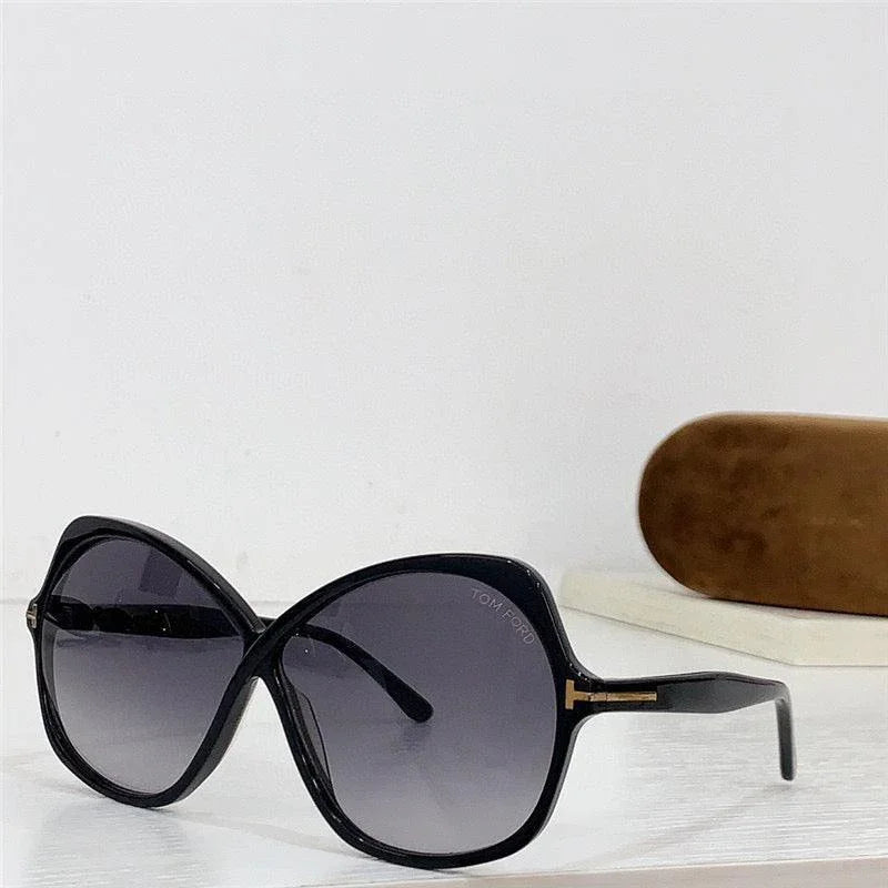 Black oversized cat eye sunglasses with gradient lenses and gold accents on white background