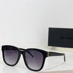 Black square sunglasses with gold accent and gradient lenses on white surface