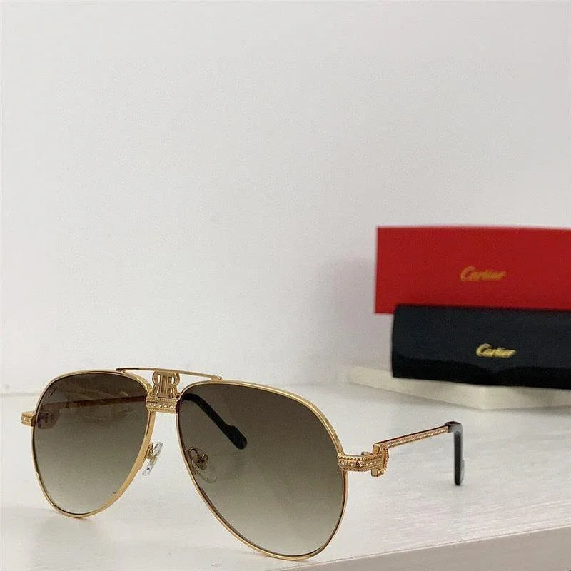 Gold aviator sunglasses with gradient lenses on white surface, red and black cases in background