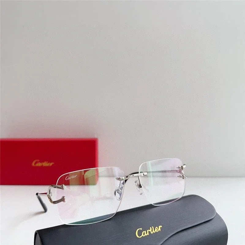 Rimless clear eyeglasses with silver temples, displayed with Cartier case and red box.