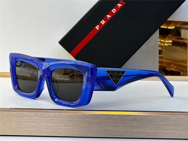 Blue rectangular sunglasses with black lenses and Prada logo on the side, luxury eyewear display.