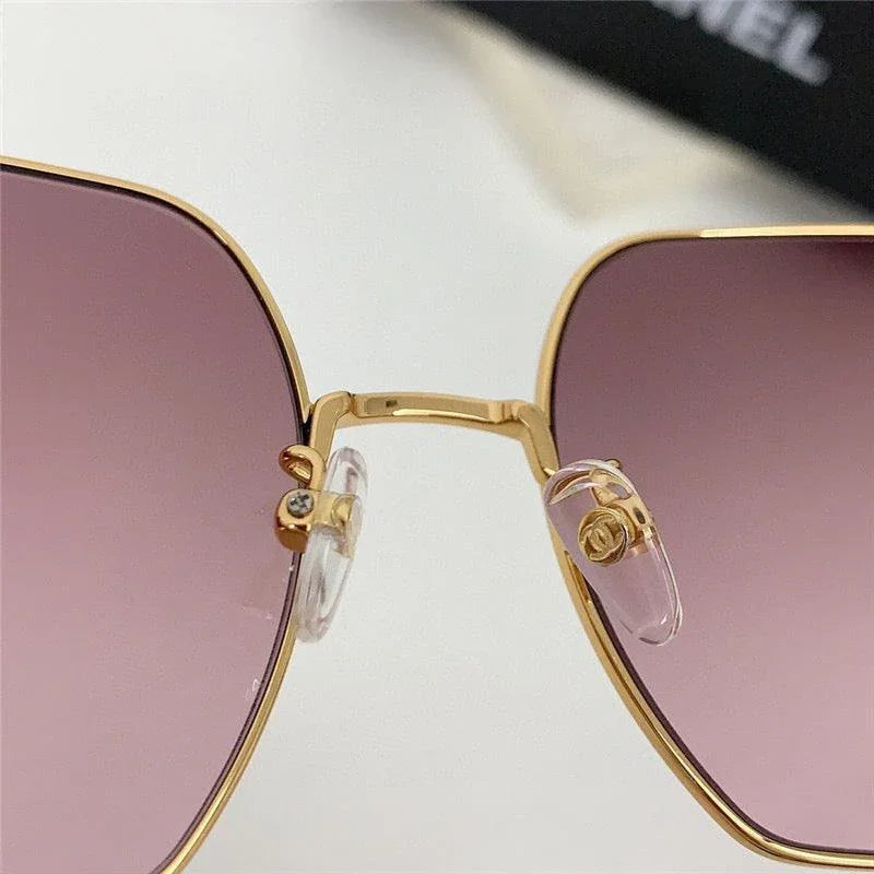 Close-up of gold frame sunglasses with purple gradient lenses and adjustable nose pads
