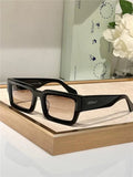 Rectangular black sunglasses with tinted lenses displayed on a light wood tray.
