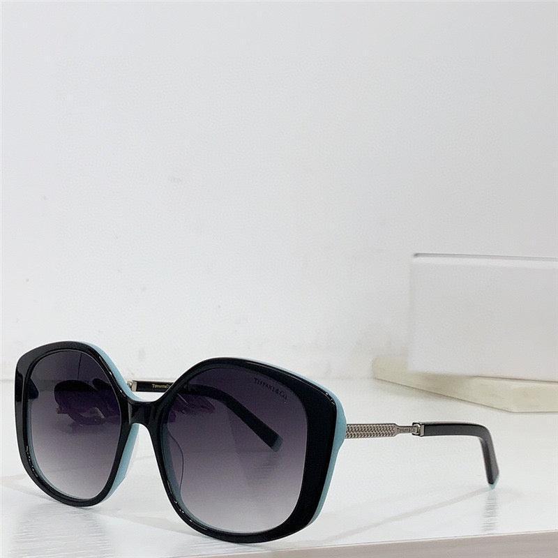 Oversized square sunglasses with gradient lenses and black and turquoise frames on a white surface