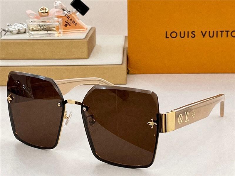 Oversized square brown sunglasses with gold metal temples featuring engraved luxury symbols, displayed on a table with designer packaging in the background.