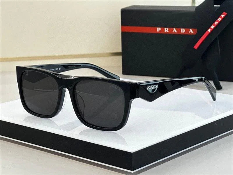 Black rectangular sunglasses with dark lenses and luxury packaging