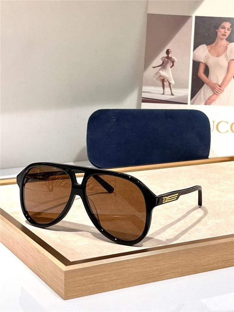 Black aviator sunglasses with brown polarized lenses on display tray, blue case in background