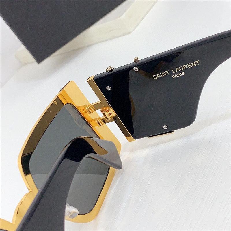 Close-up of black and gold square sunglasses with Saint Laurent Paris logo on temple, UV protection