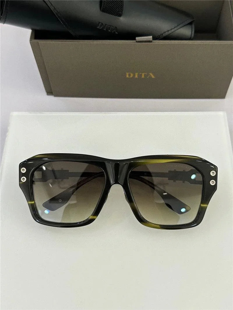 Black rectangular sunglasses with gradient lenses and studded frame, on display with case and box.