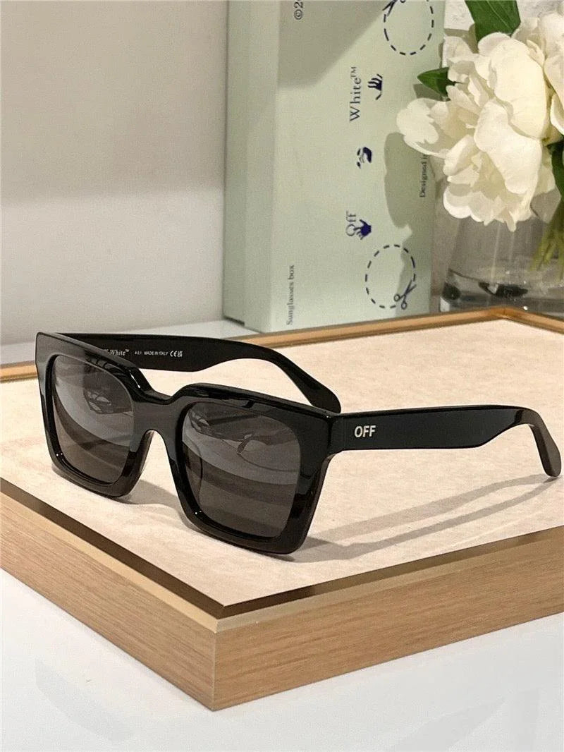 Black square oversized sunglasses with dark lenses and OFF text, displayed on a tray.
