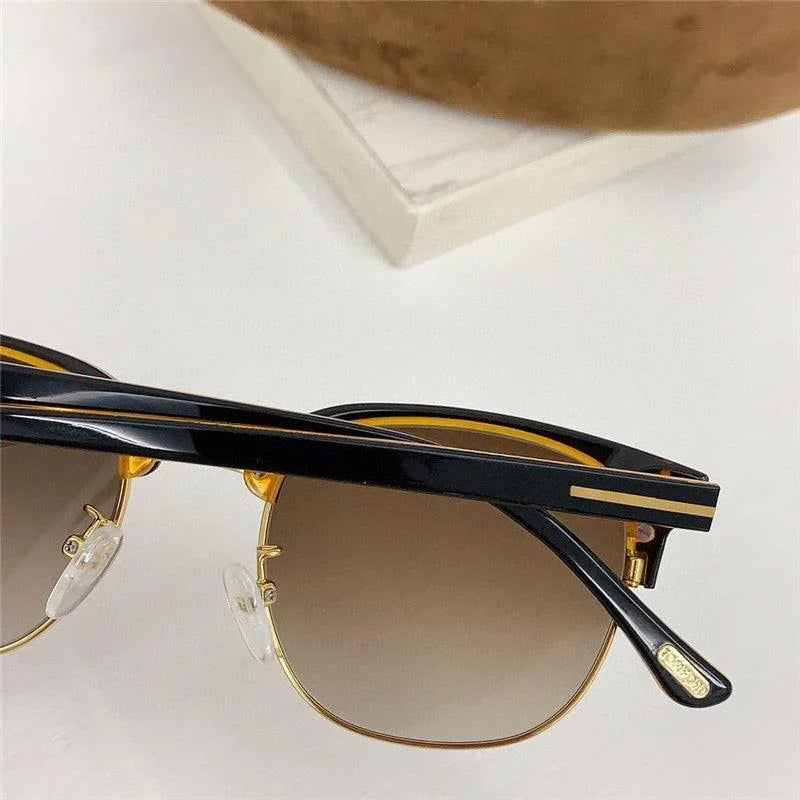 Stylish black and gold sunglasses with gradient brown lenses and UV400 protection.