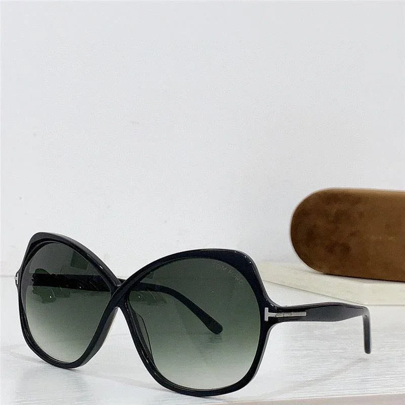 Oversized black sunglasses with gradient lenses on white surface, brown case in background