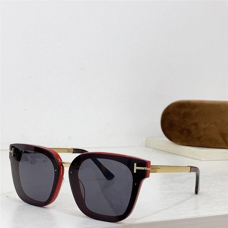 Square red and gold sunglasses with dark polarized lenses on a white surface