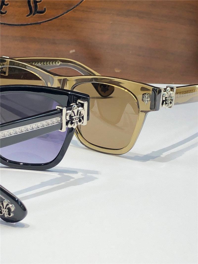 Stylish sunglasses with fleur-de-lis metal accents and colored lenses on white surface