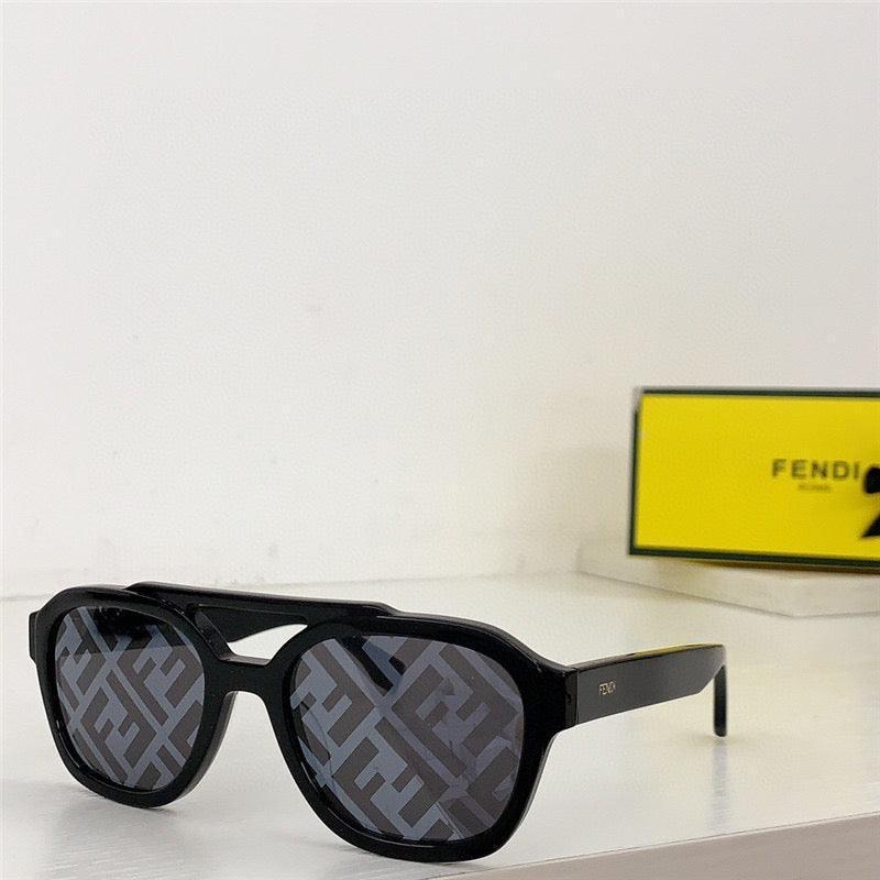 Black designer sunglasses with patterned lenses and bold frames on a white surface