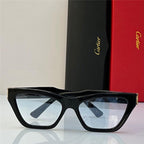Black cat-eye sunglasses with clear lenses, luxury packaging in the background