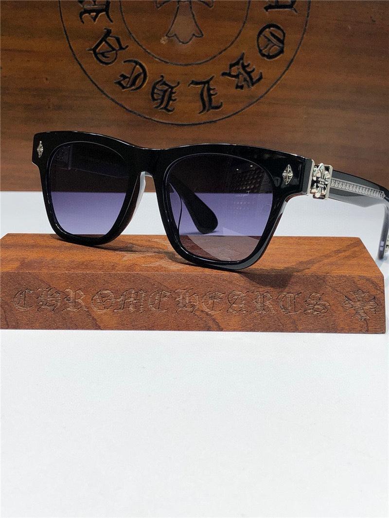 Black square sunglasses with silver detailing and gradient lenses on a wooden stand, luxury eyewear